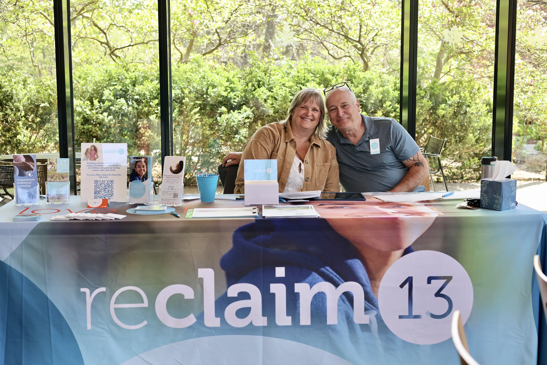 Reclaim 13 event welcome table with two smiling team members